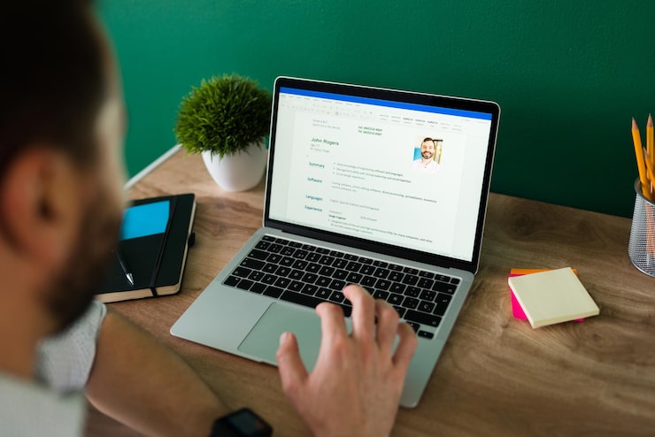 rear-view-adult-man-searching-new-job-working-writing-his-resume-laptop_662251-2153